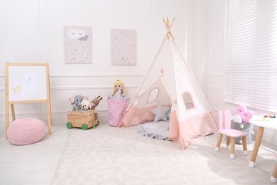 Cute child's room interior with toys, modern furniture and play tent Photo of Cute child's room interior with toys, modern furniture and play tent