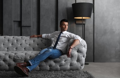 Handsome businessman on sofa indoors. Luxury lifestyle Photo of Handsome businessman on sofa indoors. Luxury lifestyle
