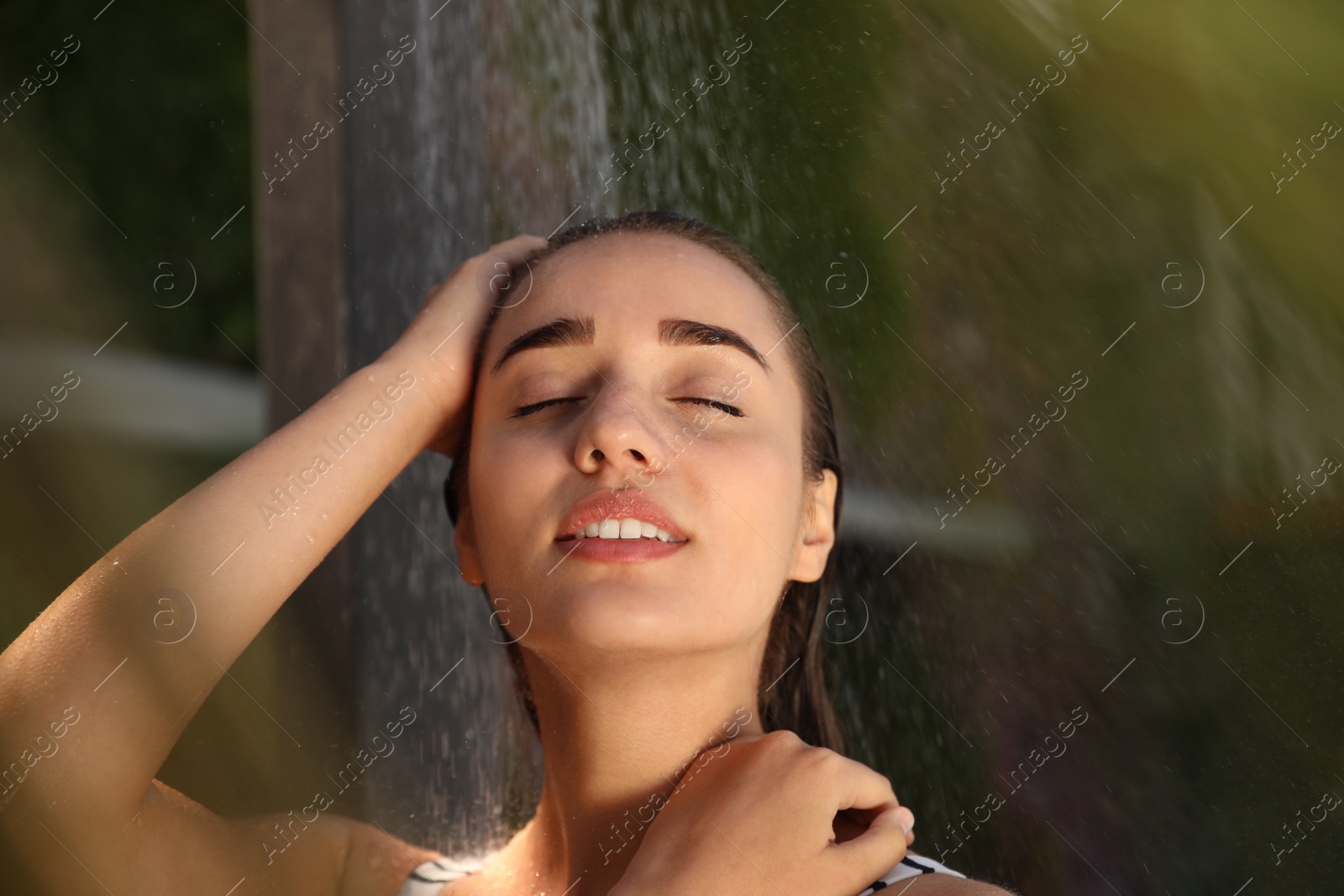 Woman washing hair in outdoor shower on summer day Photo of Woman washing hair in outdoor shower on summer day