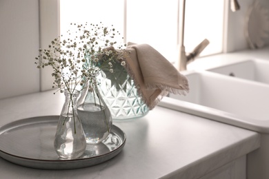 Vases with gypsophila flowers near sink in kitchen, space for text. Interior design Photo of Vases with gypsophila flowers near sink in kitchen, space for text. Interior design