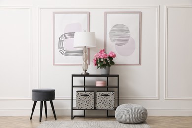Console table with beautiful hydrangea flower and lamp near white wall in hallway. Interior design Photo of Console table with beautiful hydrangea flower and lamp near white wall in hallway. Interior design