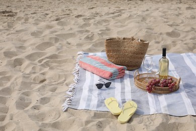 Bag, blanket, wine and other stuff for beach picnic on sand Photo of Bag, blanket, wine and other stuff for beach picnic on sand
