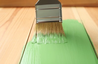 Applying green paint onto wooden surface, closeup Photo of Applying green paint onto wooden surface, closeup