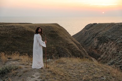 Jesus Christ on hills at sunset. Space for text Photo of Jesus Christ on hills at sunset. Space for text