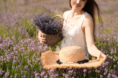 Young woman with straw hat in lavender field on summer day, closeup Photo of Young woman with straw hat in lavender field on summer day, closeup