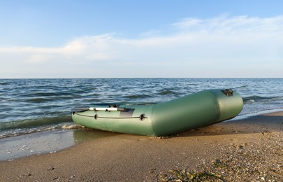 Inflatable rubber fishing boat on sandy beach near sea Photo of Inflatable rubber fishing boat on sandy beach near sea
