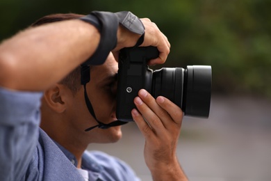 Photographer taking picture with professional camera outdoors, closeup Photo of Photographer taking picture with professional camera outdoors, closeup