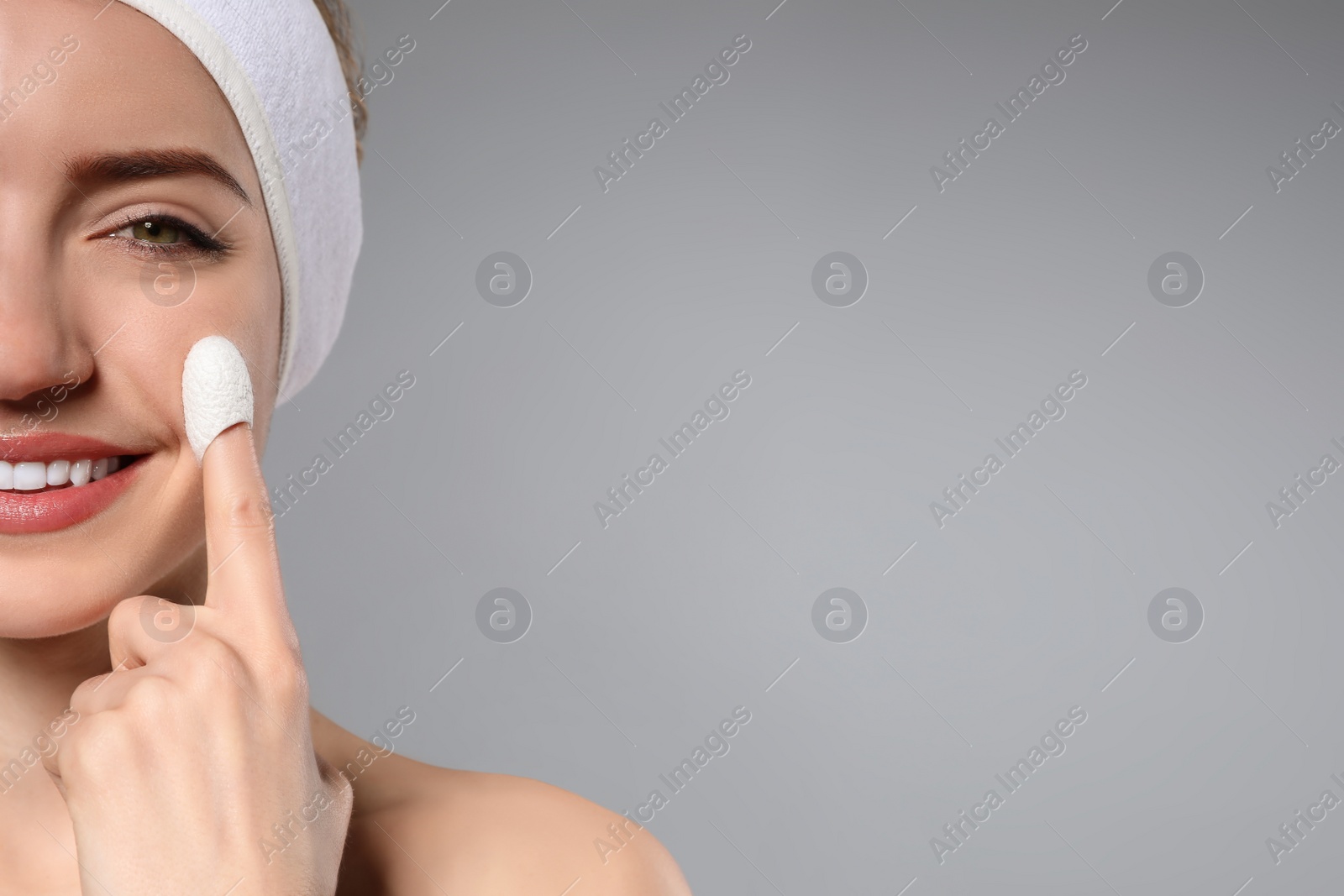 Woman using silkworm cocoon in skin care routine on grey background, closeup. Space for text Photo of Woman using silkworm cocoon in skin care routine on grey background, closeup. Space for text