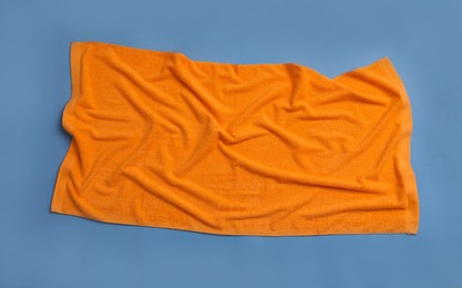 Crumpled orange beach towel on blue background, top view Photo of Crumpled orange beach towel on blue background, top view