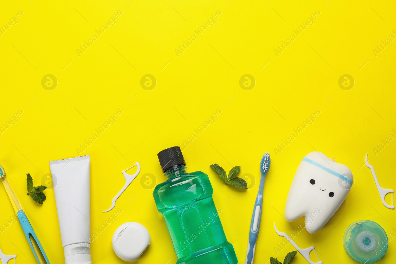 Flat lay composition with mouthwash and other oral hygiene products on yellow background. Space for text Photo of Flat lay composition with mouthwash and other oral hygiene products on yellow background. Space for text