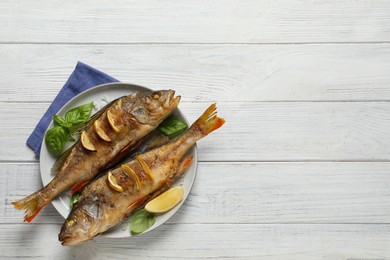Tasty homemade roasted perches on white wooden table, top view and space for text. River fish Photo of Tasty homemade roasted perches on white wooden table, top view and space for text. River fish