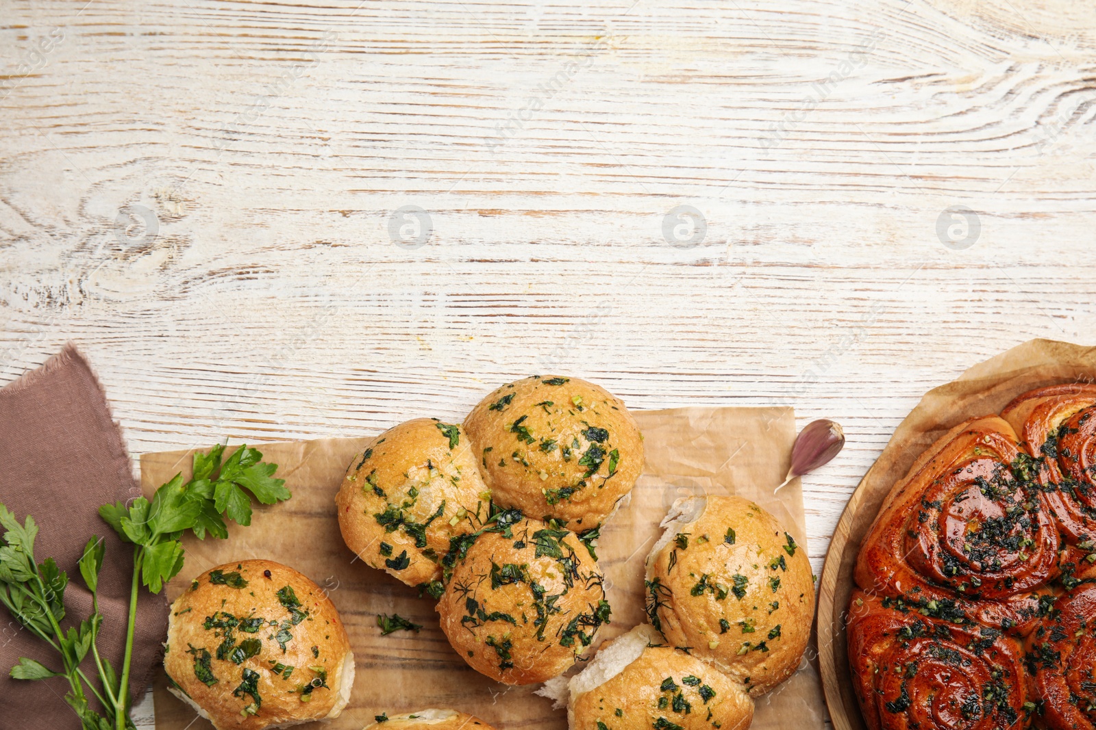 Traditional Ukrainian bread (Pampushky) with garlic on white wooden table, flat lay. Space for text Photo of Traditional Ukrainian bread (Pampushky) with garlic on white wooden table, flat lay. Space for text