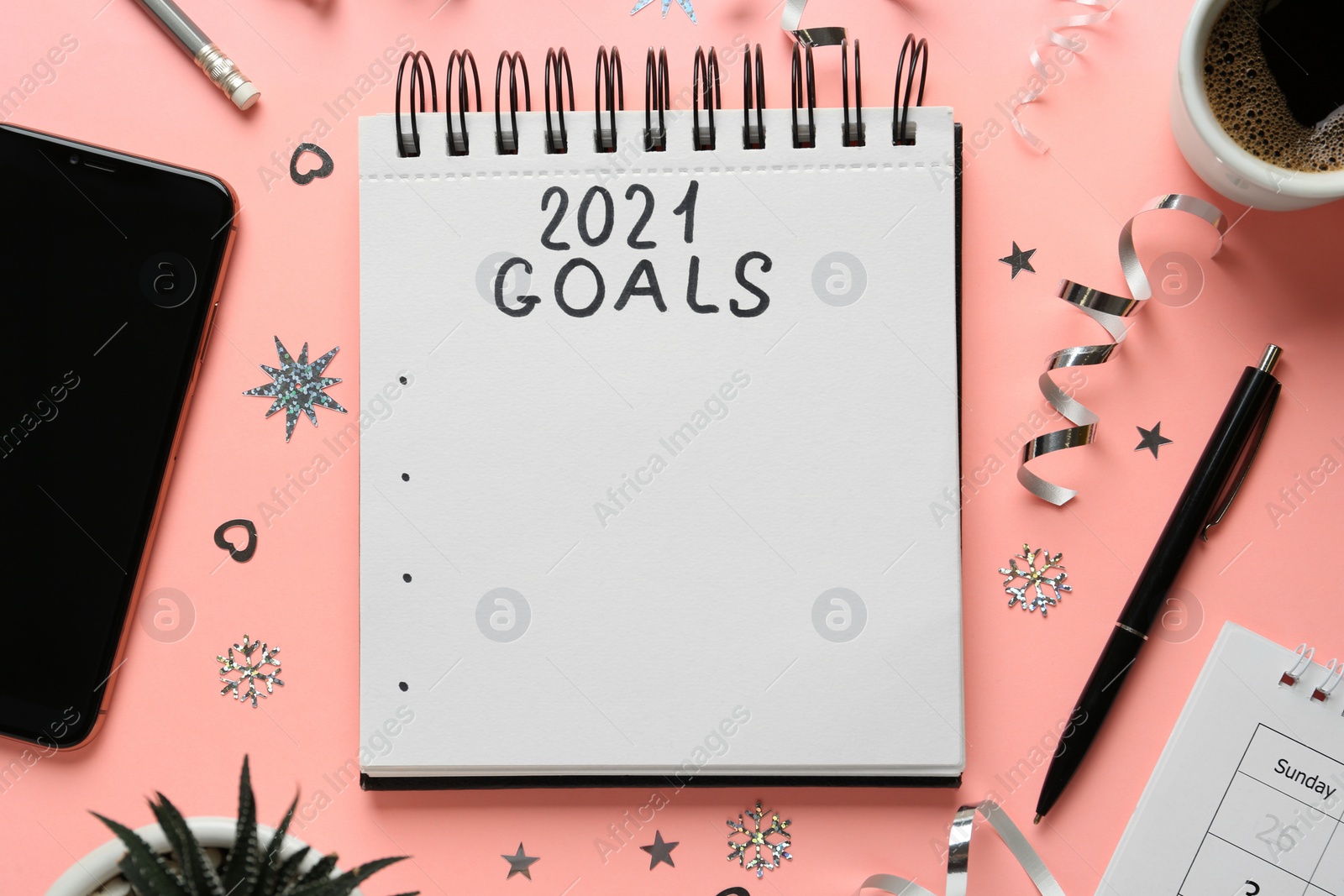 Flat lay composition with notebook and festive decor on pink background. Goals for New Year 2021 Photo of Flat lay composition with notebook and festive decor on pink background. Goals for New Year 2021