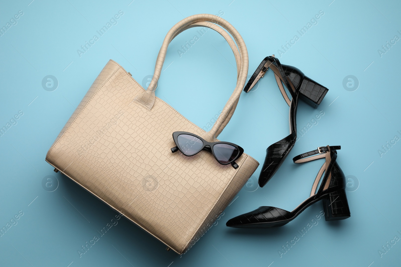 Stylish woman's bag, sunglasses and shoes on beige background, flat lay Photo of Stylish woman's bag, sunglasses and shoes on beige background, flat lay