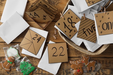 Flat lay composition with gift bags and Christmas cookies on wooden table. Creating advent calendar Photo of Flat lay composition with gift bags and Christmas cookies on wooden table. Creating advent calendar