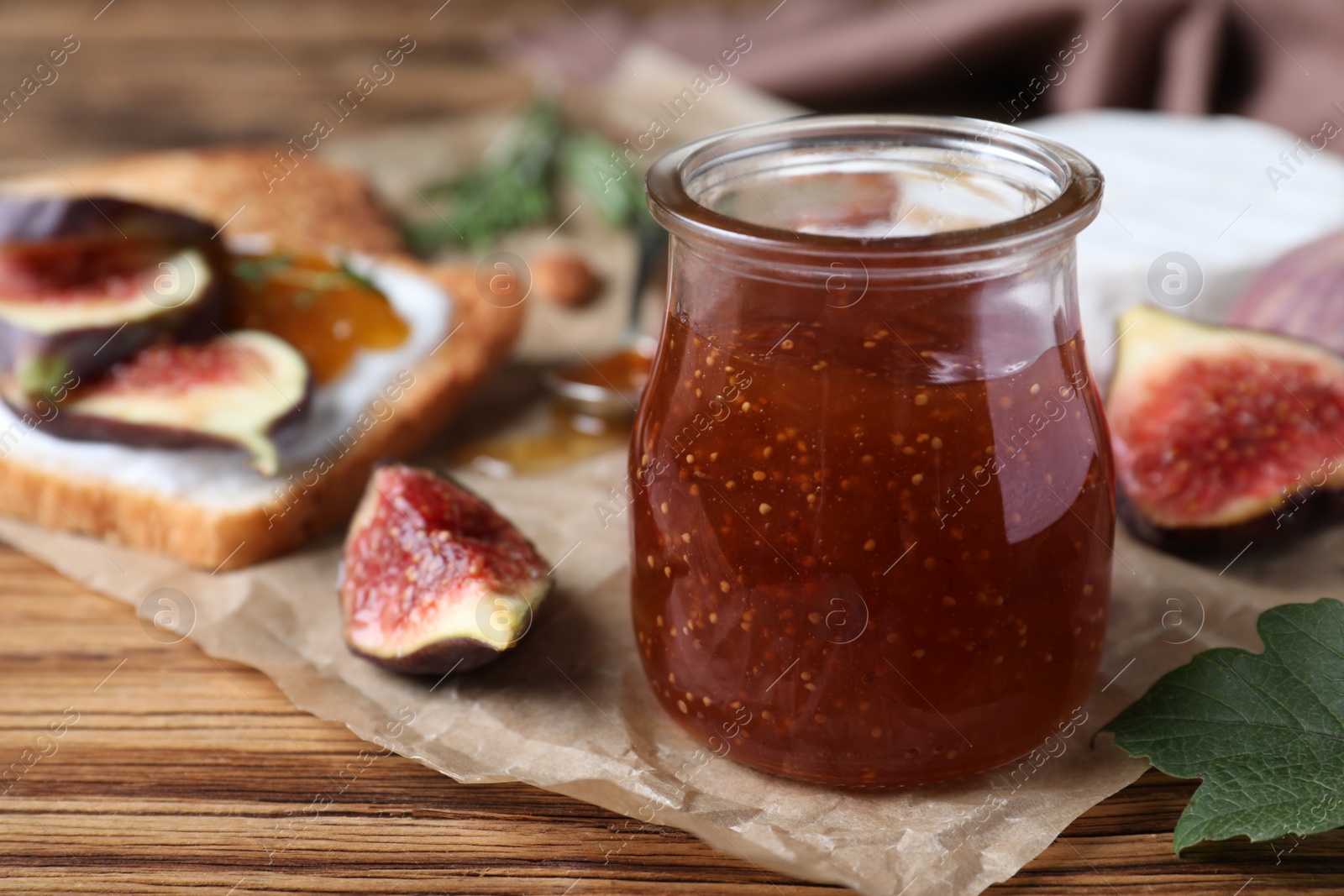 Delicious fig jam on wooden table, closeup. Space for text Photo of Delicious fig jam on wooden table, closeup. Space for text
