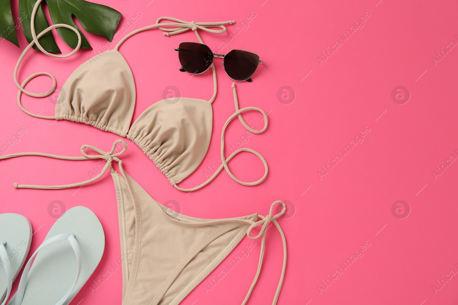 Flat lay composition with stylish bikini on pink background. Space for text Photo of Flat lay composition with stylish bikini on pink background. Space for text