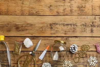 Instruments and materials for snow globe on wooden table, flat lay. Space for text Photo of Instruments and materials for snow globe on wooden table, flat lay. Space for text