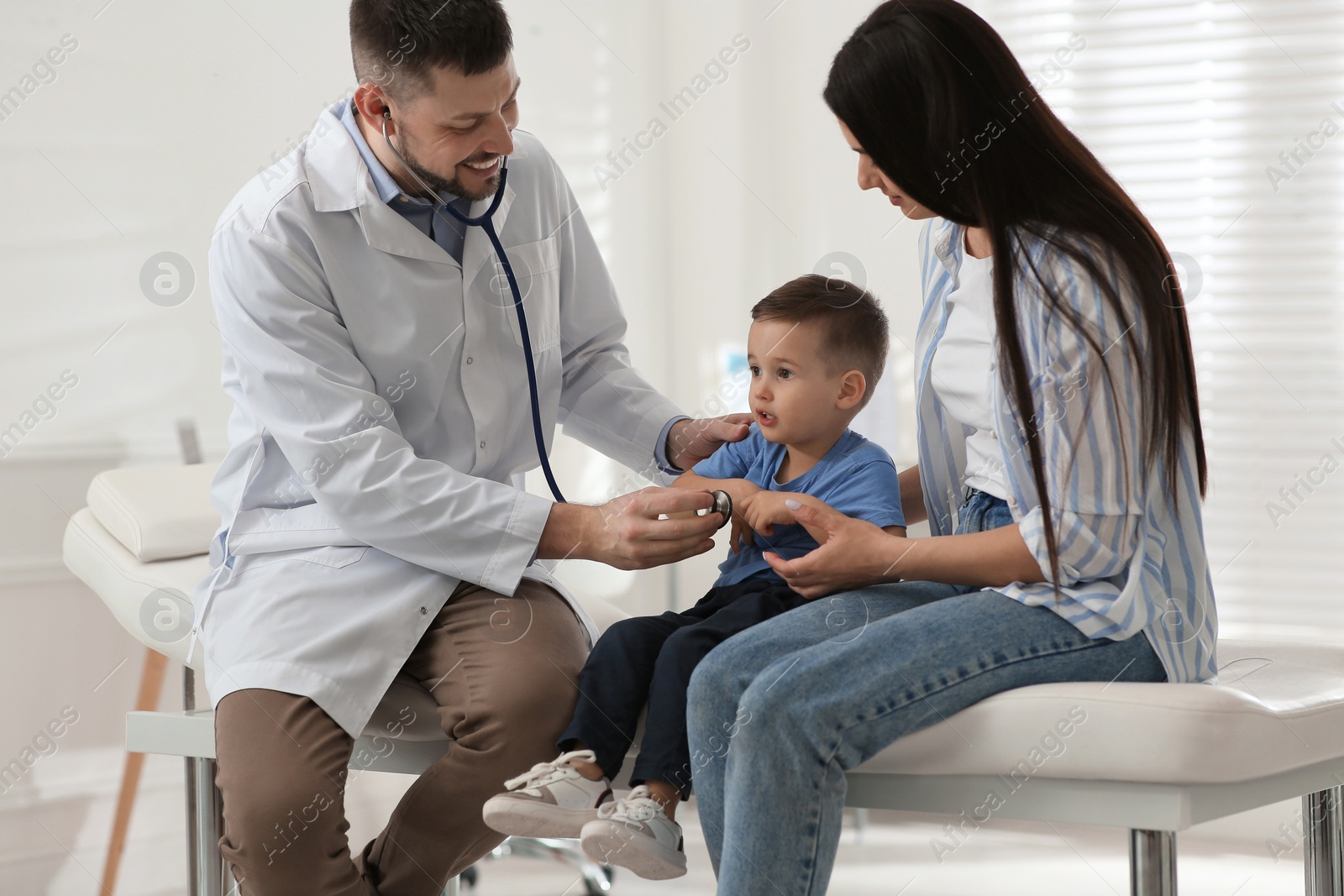 Mother and son visiting pediatrician in hospital. Doctor examining little boy Photo of Mother and son visiting pediatrician in hospital. Doctor examining little boy