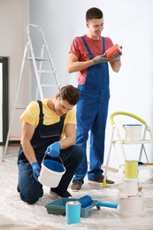 Male decorators working with paint indoors Photo of Male decorators working with paint indoors