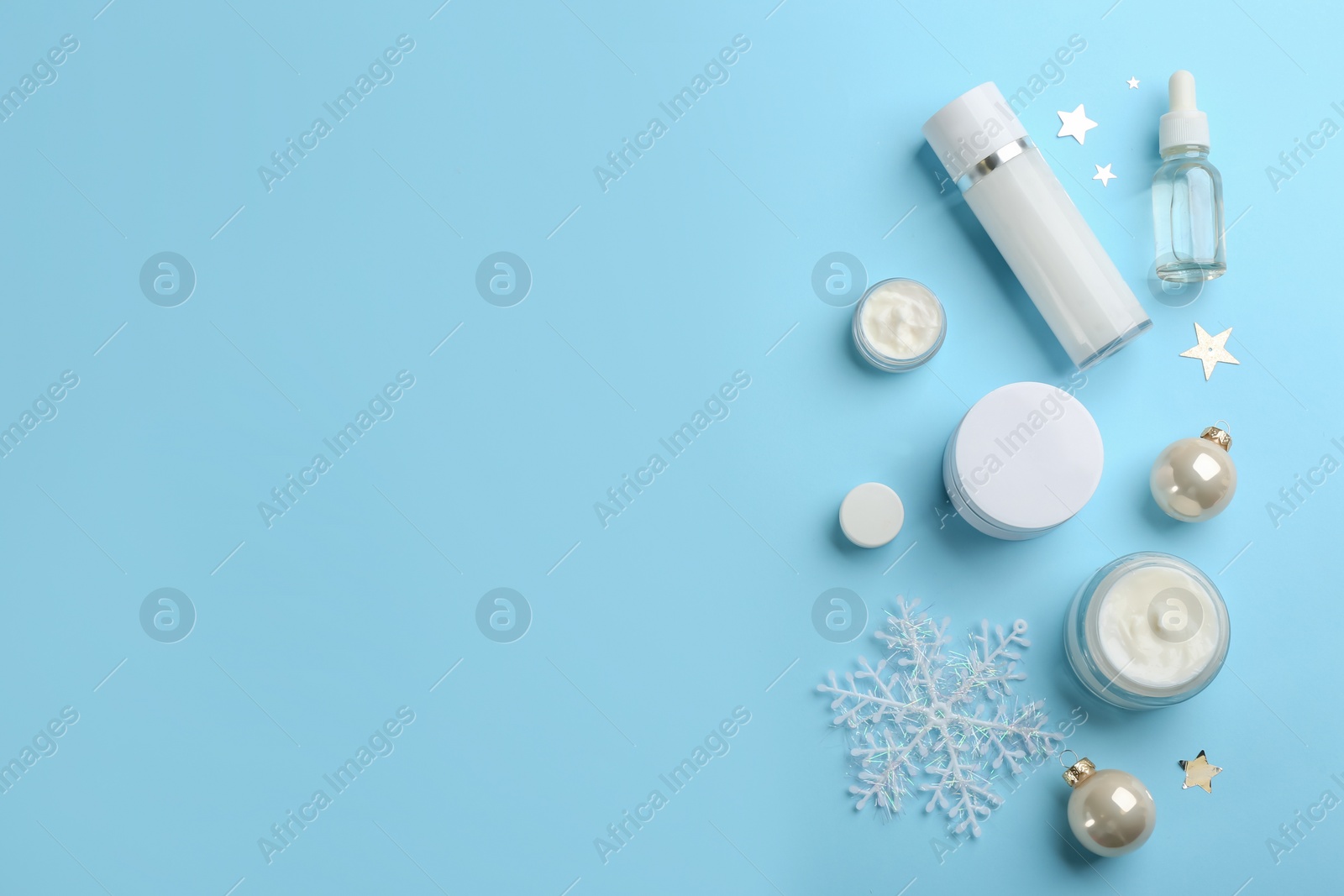Flat lay composition with different cosmetic products on light blue background, space for text. Winter care Photo of Flat lay composition with different cosmetic products on light blue background, space for text. Winter care