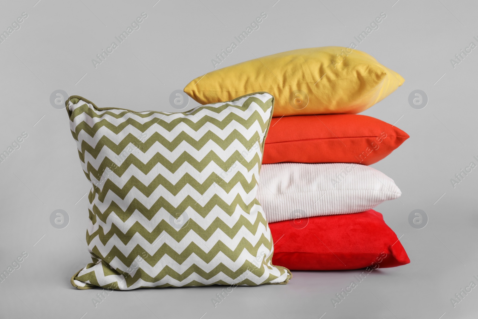 Photo of Different stylish soft pillows on grey background