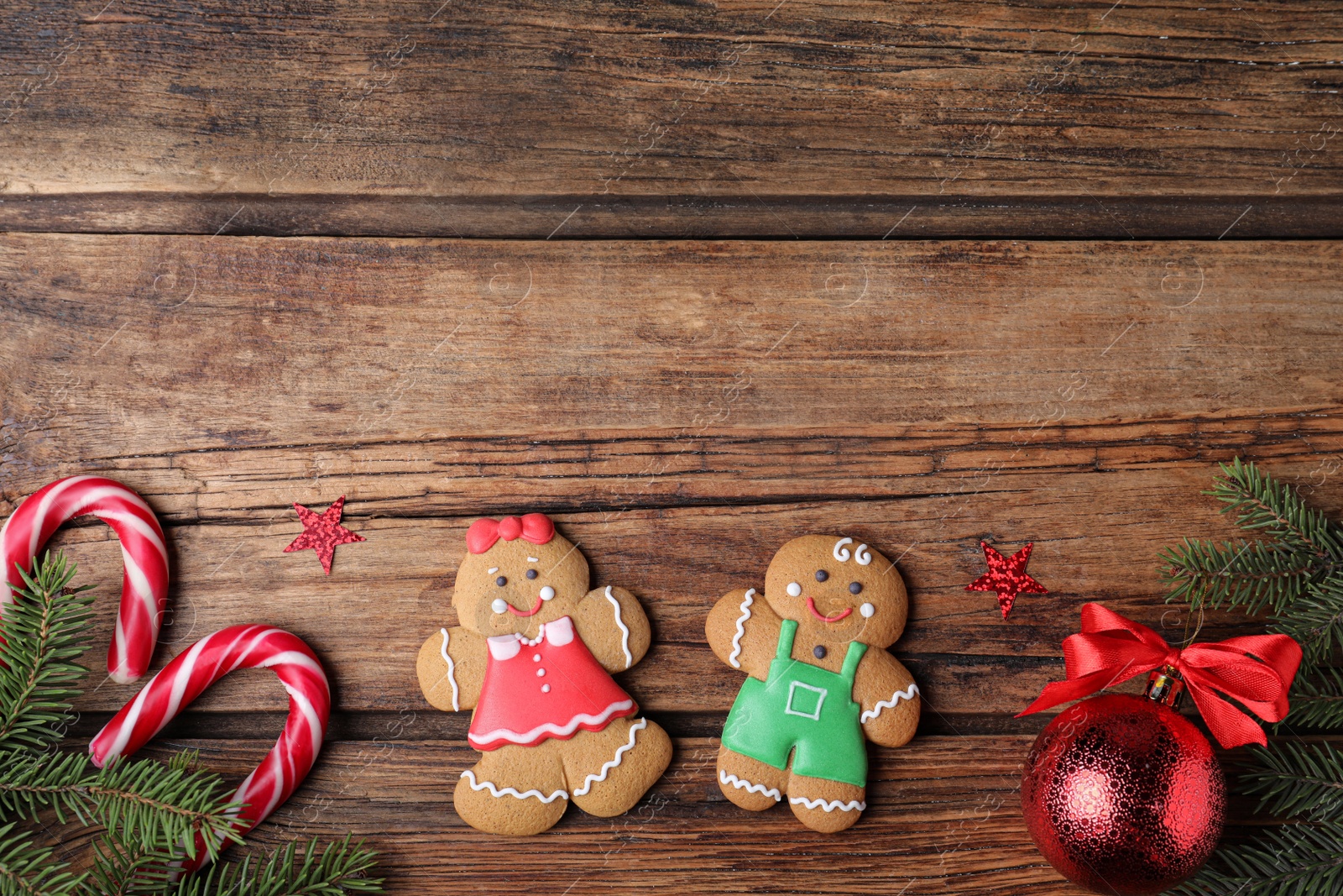 Flat lay composition with gingerbread couple on wooden table, space for text Photo of Flat lay composition with gingerbread couple on wooden table, space for text