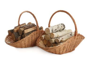 Wicker baskets with firewood on white background Photo of Wicker baskets with firewood on white background