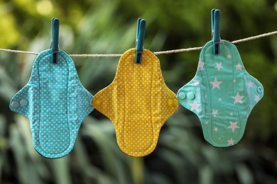 Many different menstrual cloth pads hanging on rope outdoors Photo of Many different menstrual cloth pads hanging on rope outdoors