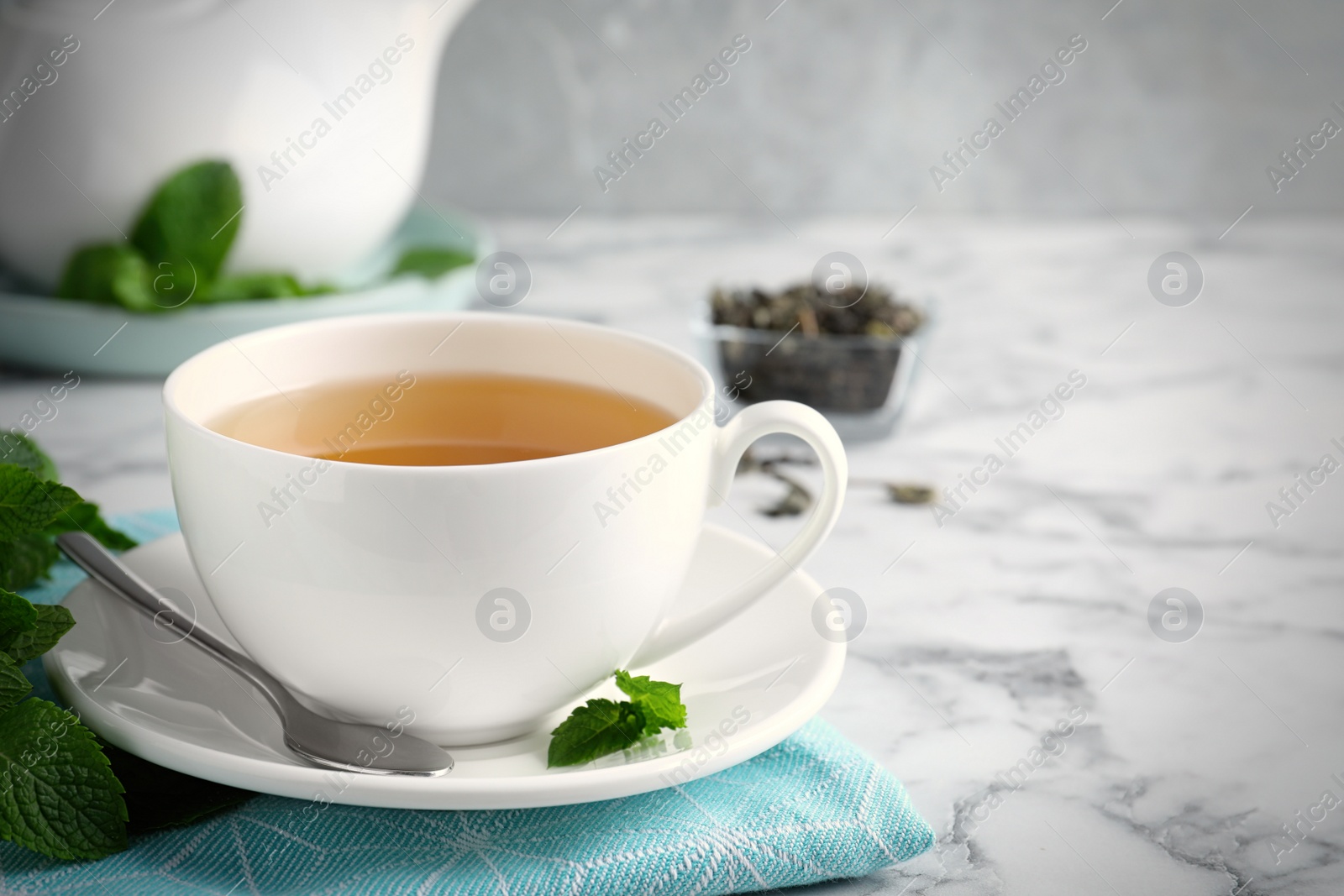 Fresh tea with mint on white marble table. Space for text Photo of Fresh tea with mint on white marble table. Space for text