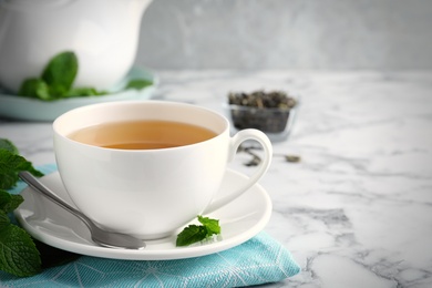 Fresh tea with mint on white marble table. Space for text Photo of Fresh tea with mint on white marble table. Space for text
