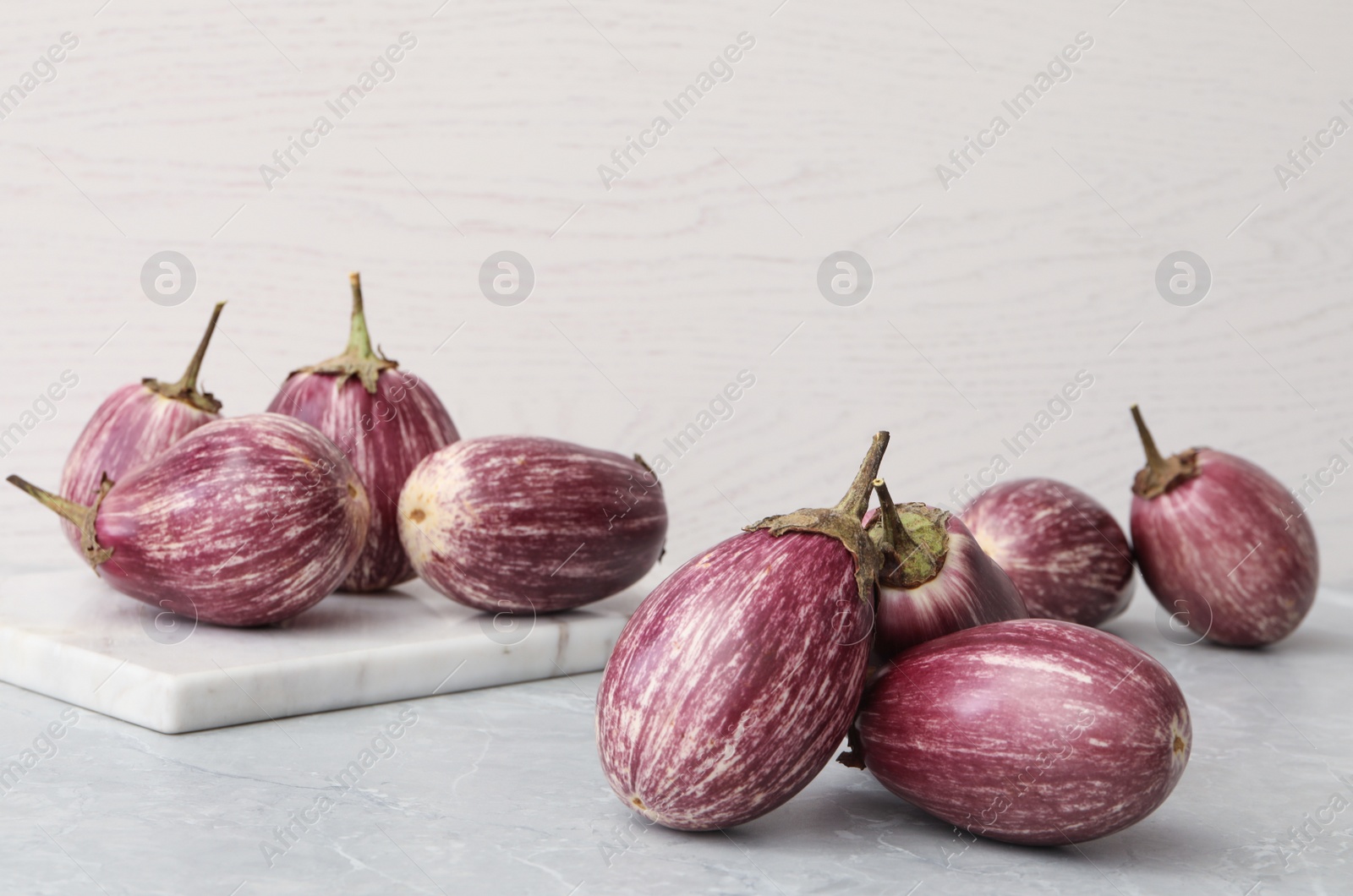 Many raw ripe eggplants on grey table Photo of Many raw ripe eggplants on grey table