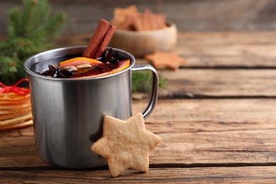 Aromatic mulled wine and cookie on wooden table, closeup. Space for text Photo of Aromatic mulled wine and cookie on wooden table, closeup. Space for text