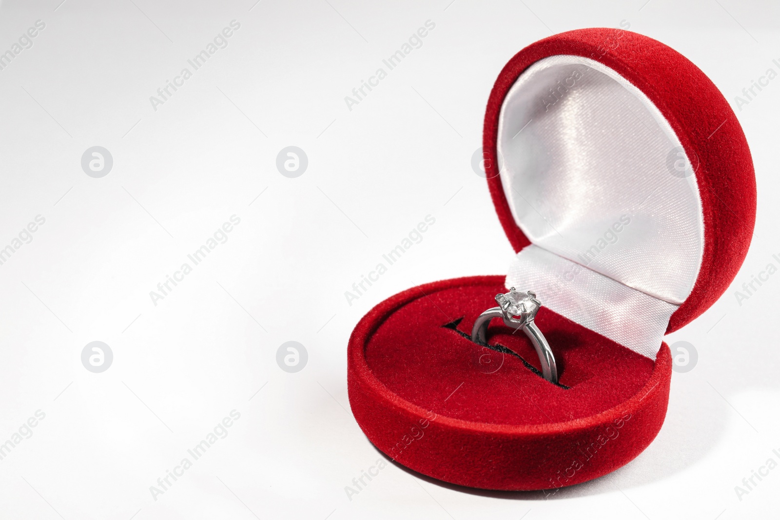 Beautiful engagement ring in red box on white background, space for text Photo of Beautiful engagement ring in red box on white background, space for text