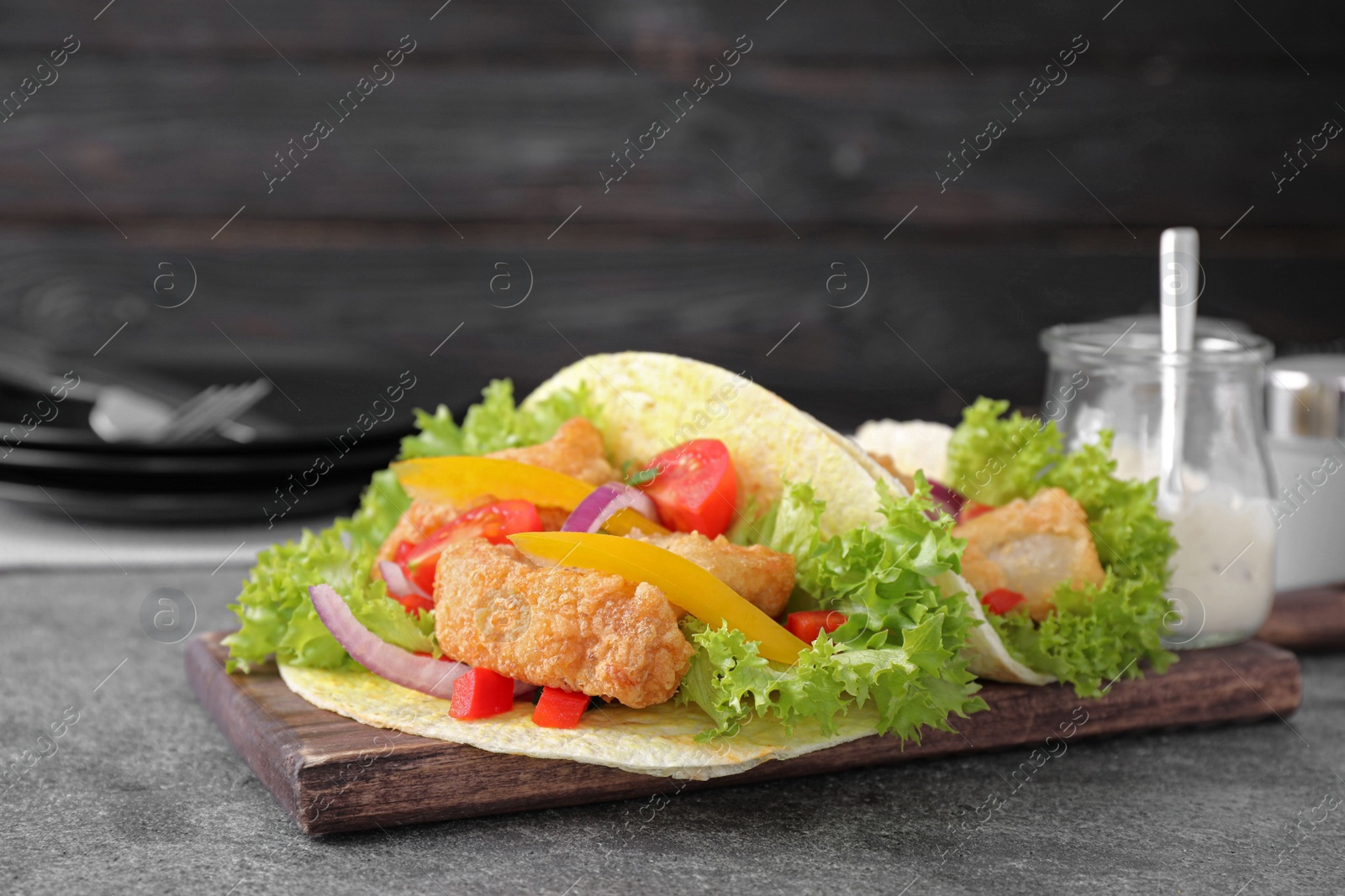 Delicious fish tacos served on grey table Photo of Delicious fish tacos served on grey table