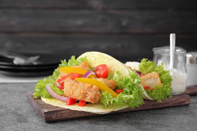 Photo of Delicious fish tacos served on grey table
