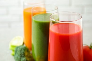 Different tasty juices in glasses, closeup. Space for text Photo of Different tasty juices in glasses, closeup. Space for text