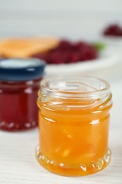 Open glass jar of sweet jam on white wooden table, closeup. Space for text Photo of Open glass jar of sweet jam on white wooden table, closeup. Space for text