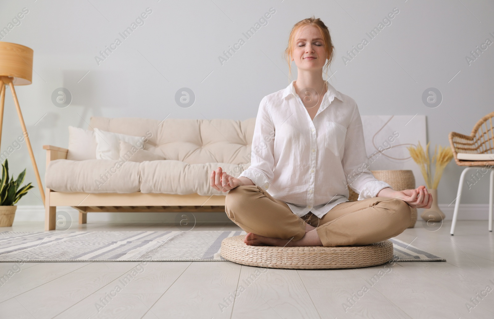 Woman meditating on wicker mat at home. Space for text Photo of Woman meditating on wicker mat at home. Space for text