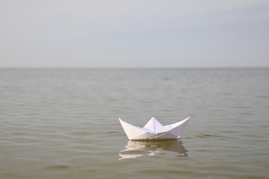 White paper boat on water surface, space for text Photo of White paper boat on water surface, space for text