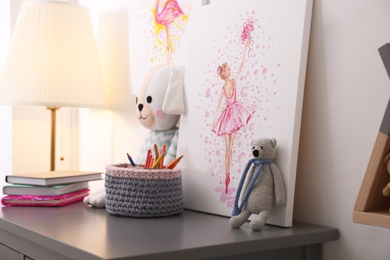 Picture and stationery with toys on chest of drawers in children's room. Interior design Photo of Picture and stationery with toys on chest of drawers in children's room. Interior design