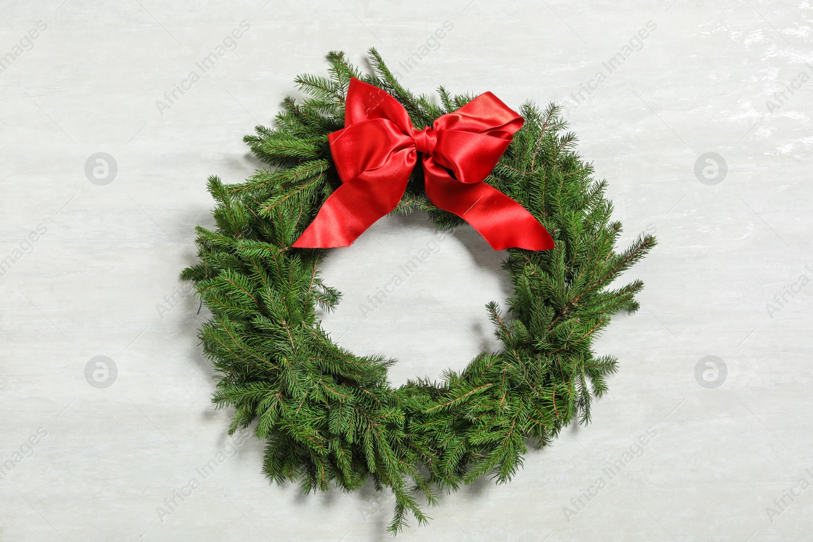 Christmas wreath made of fir branches with red bow on white background Photo of Christmas wreath made of fir branches with red bow on white background