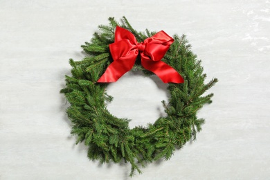 Christmas wreath made of fir branches with red bow on white background Photo of Christmas wreath made of fir branches with red bow on white background