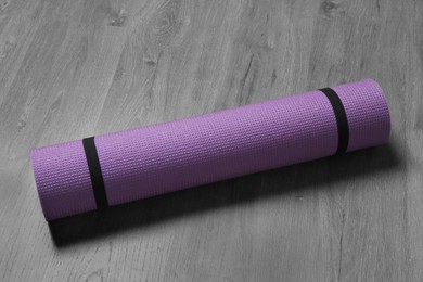 Bright rolled camping mat on grey wooden background Photo of Bright rolled camping mat on grey wooden background