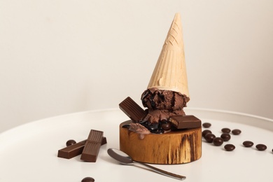 Delicious ice cream with chocolate in wafer cone served on white table Photo of Delicious ice cream with chocolate in wafer cone served on white table
