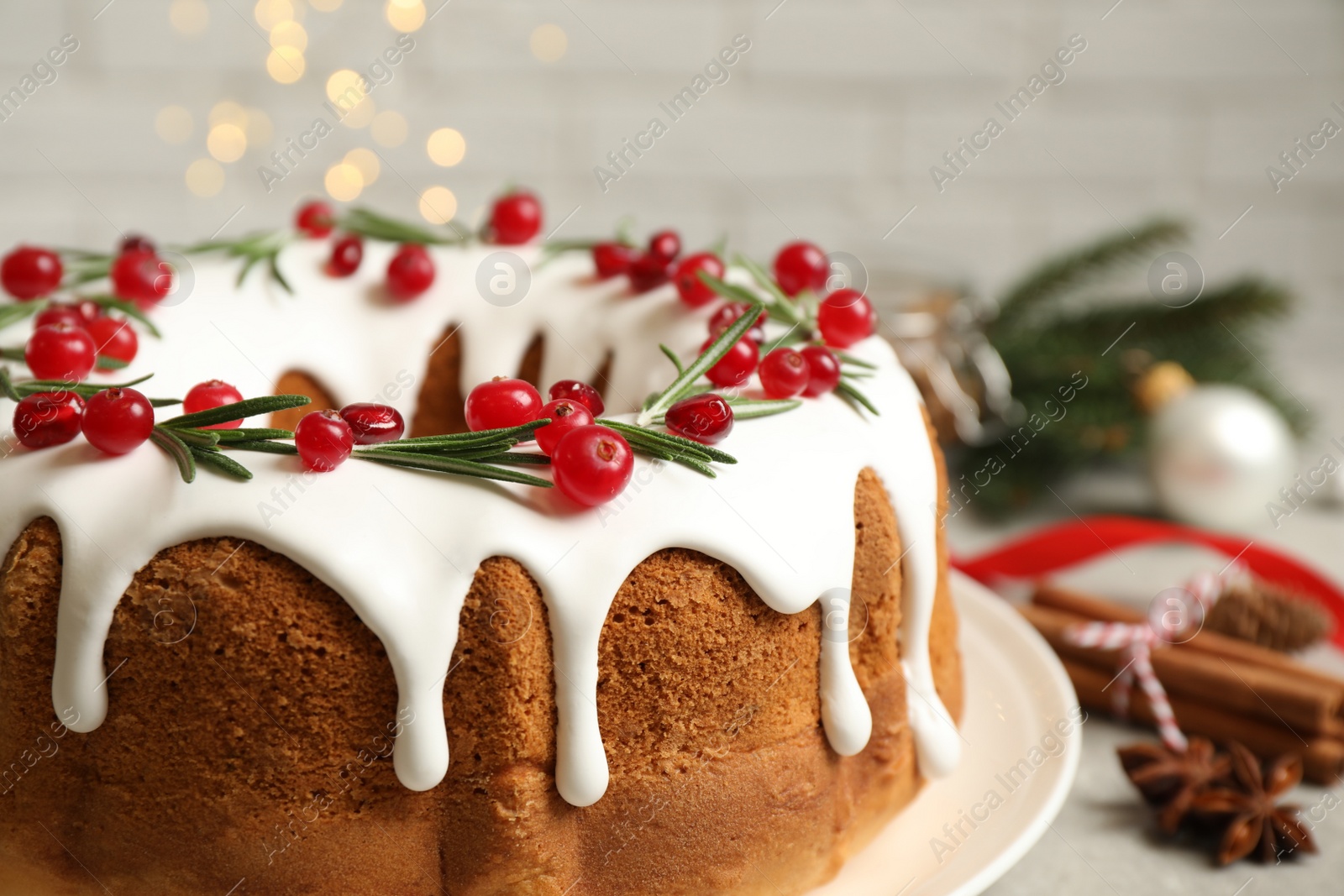 Traditional Christmas cake with cranberries, pomegranate seeds and rosemary on table, closeup Photo of Traditional Christmas cake with cranberries, pomegranate seeds and rosemary on table, closeup
