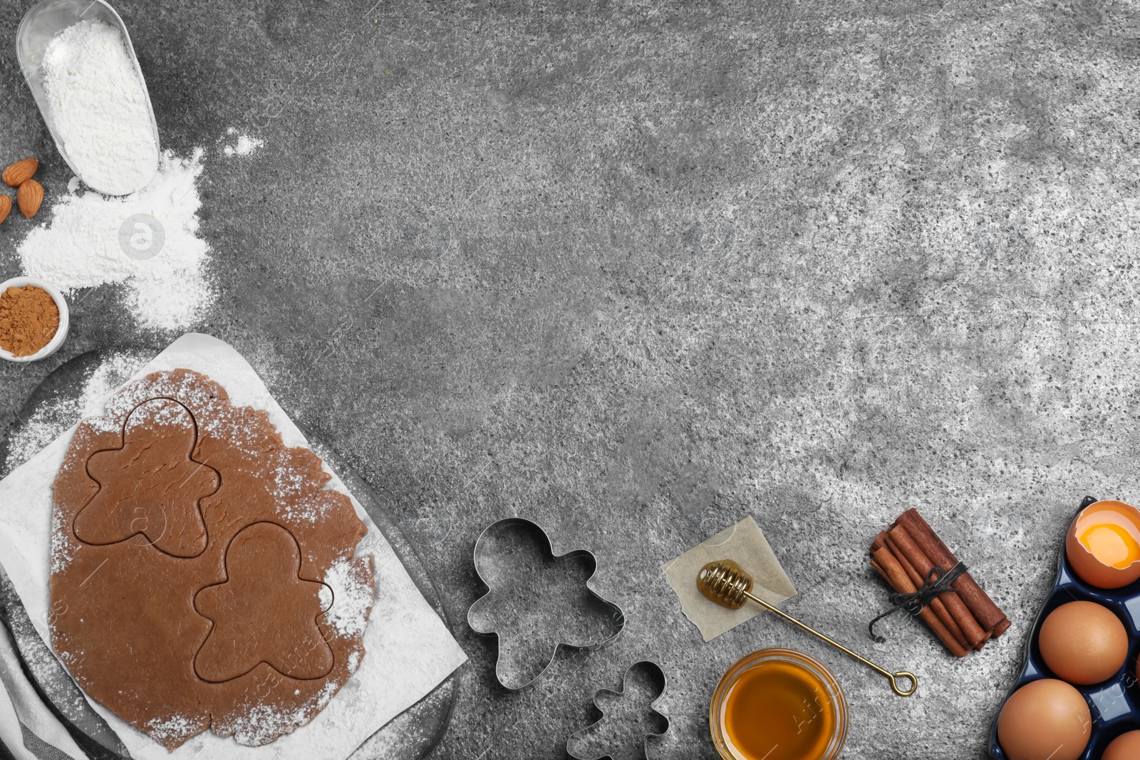 Flat lay composition with homemade gingerbread man cookies on grey table, space for text Photo of Flat lay composition with homemade gingerbread man cookies on grey table, space for text