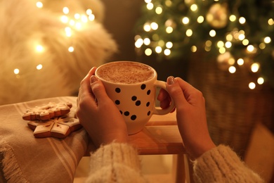 Woman with cup of hot drink and Christmas cookies at home, closeup Photo of Woman with cup of hot drink and Christmas cookies at home, closeup
