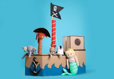 Pirate cardboard ship and toys on turquoise background Photo of Pirate cardboard ship and toys on turquoise background