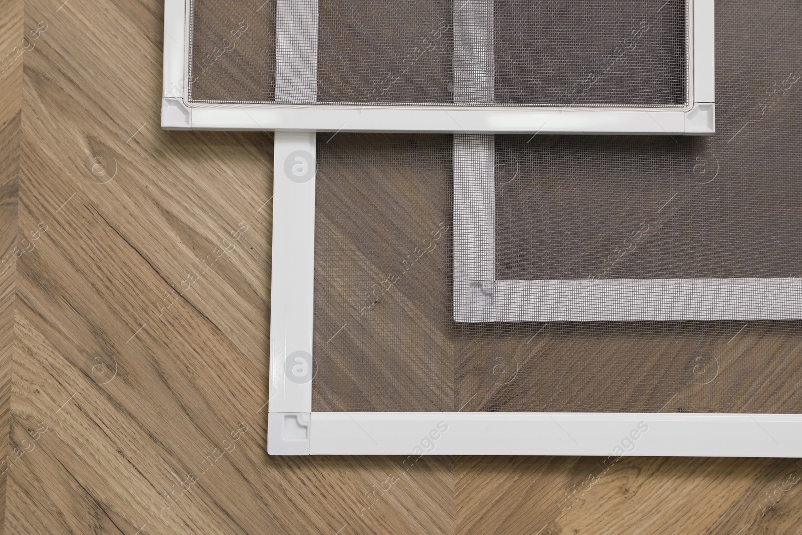 Set of window screens on wooden floor, flat lay Photo of Set of window screens on wooden floor, flat lay
